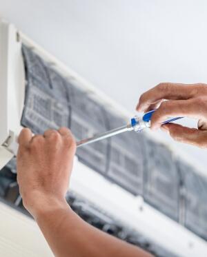 man fixing ac unit